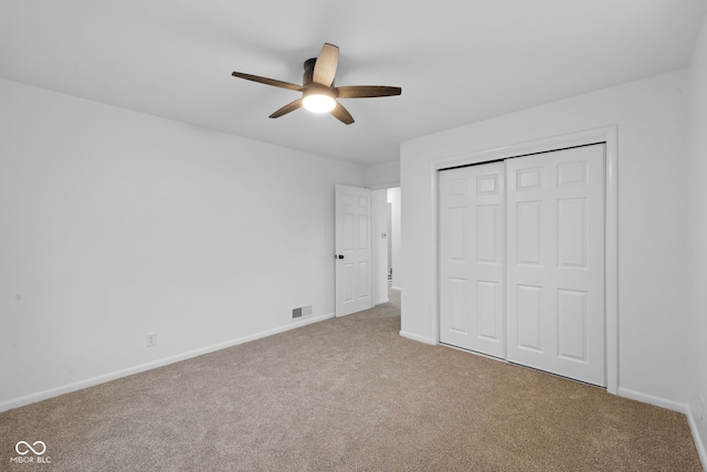 unfurnished bedroom with carpet, ceiling fan, and a closet