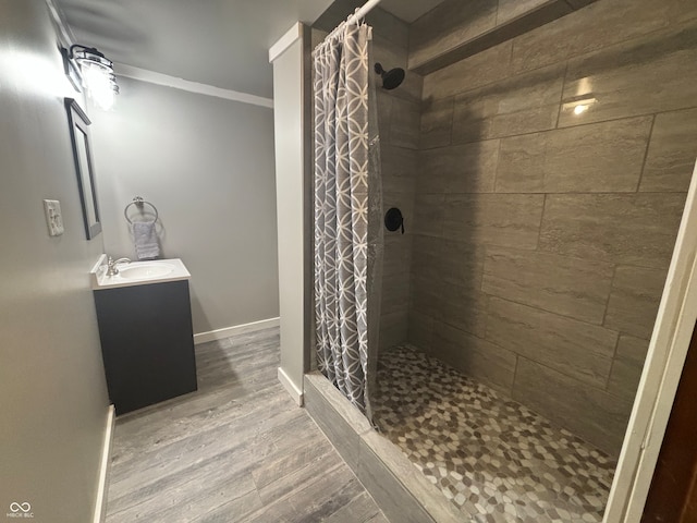 bathroom featuring hardwood / wood-style floors, vanity, ornamental molding, and walk in shower