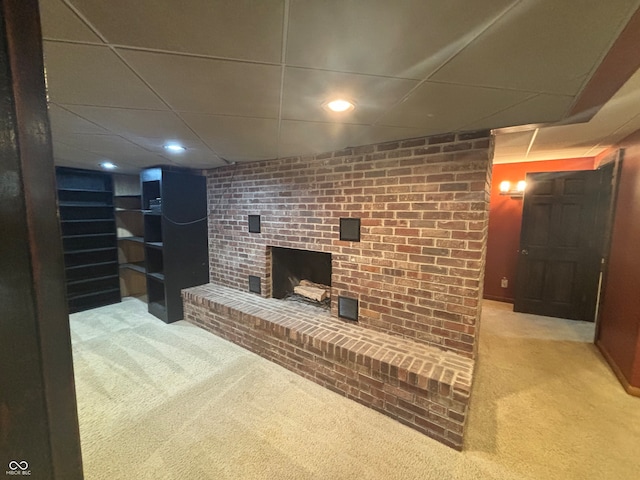 living room featuring a paneled ceiling, a fireplace, and carpet