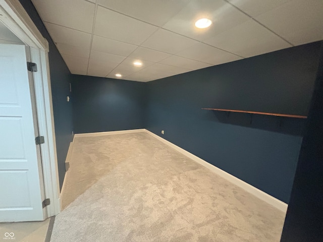 empty room featuring carpet and a drop ceiling