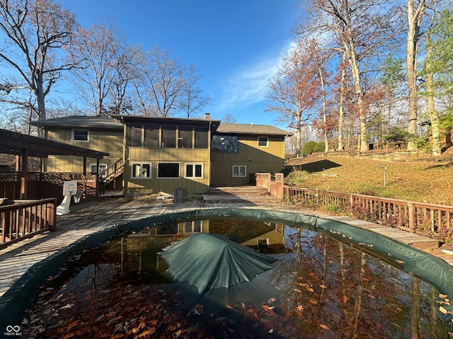 rear view of property featuring a covered pool and a sunroom