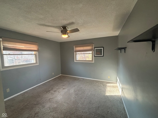 unfurnished room with carpet flooring, ceiling fan, and a textured ceiling