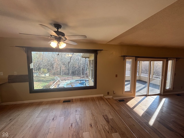 empty room with hardwood / wood-style floors and a healthy amount of sunlight