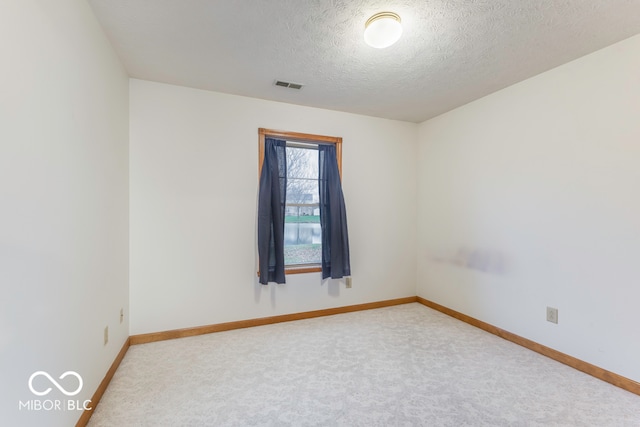 carpeted empty room featuring a textured ceiling