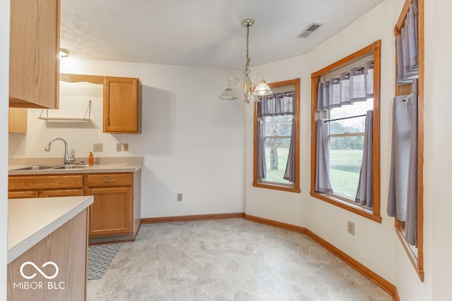 kitchen with a chandelier, hanging light fixtures, and sink