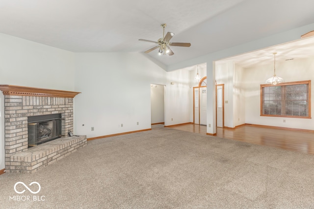 unfurnished living room featuring a fireplace, light colored carpet, ceiling fan, and lofted ceiling