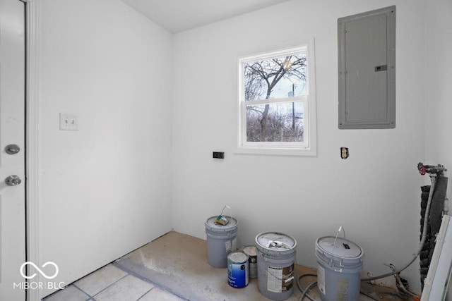 clothes washing area featuring electric panel and light tile patterned floors