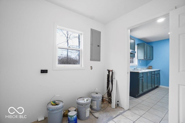 interior space with electric panel, sink, and light tile patterned floors