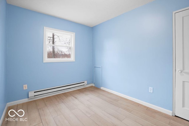 spare room with light hardwood / wood-style flooring and a baseboard heating unit