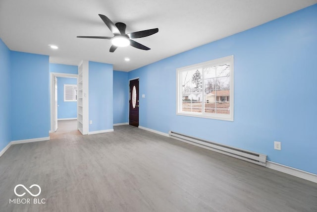 empty room with ceiling fan, wood-type flooring, and baseboard heating