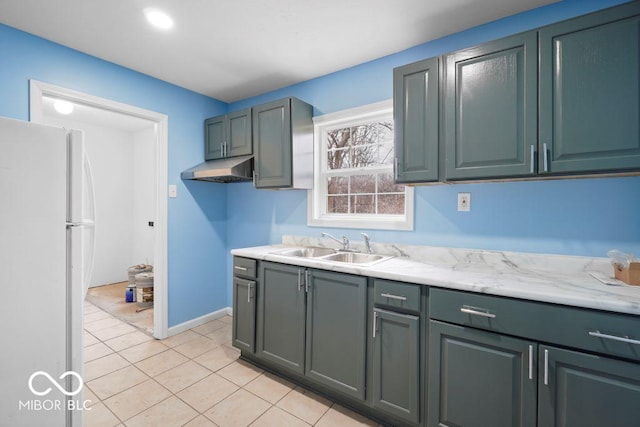 kitchen with white fridge, light tile patterned floors, and sink