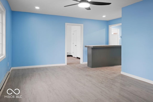 empty room with ceiling fan, wood-type flooring, and a baseboard radiator