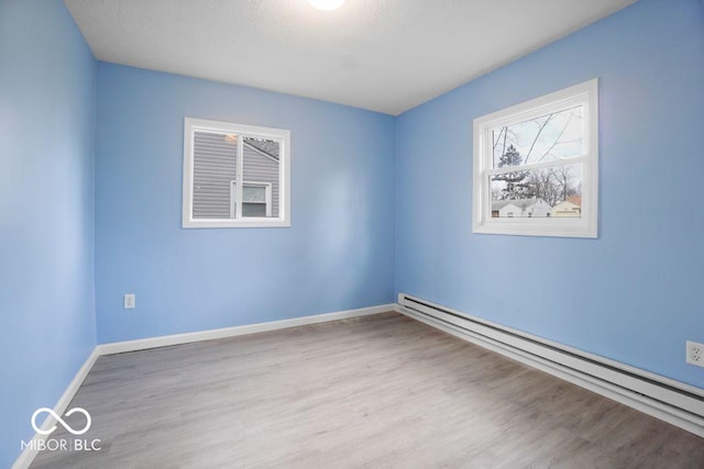 spare room with light hardwood / wood-style floors and a baseboard heating unit