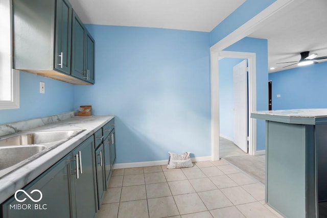 kitchen with kitchen peninsula, light tile patterned floors, ceiling fan, and sink