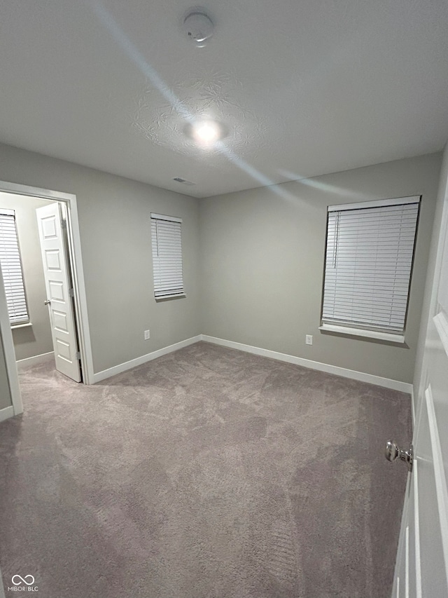 empty room featuring carpet floors and a textured ceiling