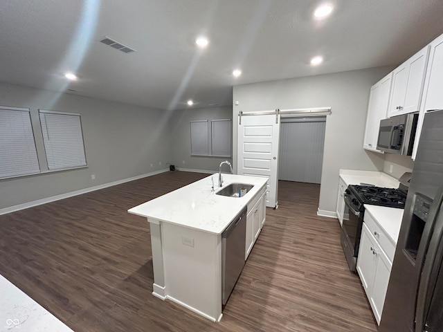 kitchen featuring stainless steel appliances, a kitchen island with sink, dark wood-type flooring, sink, and a barn door