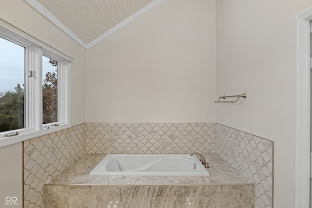 bathroom with tiled bath, crown molding, and vaulted ceiling