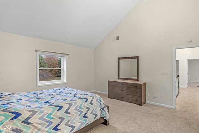 carpeted bedroom with high vaulted ceiling