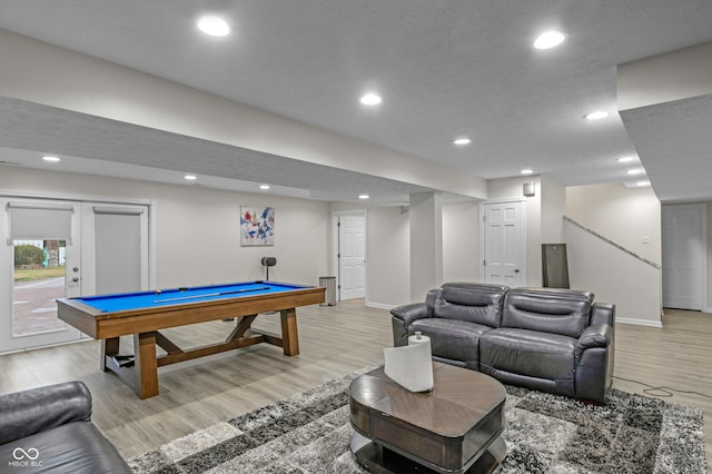 rec room with pool table, a textured ceiling, and light wood-type flooring