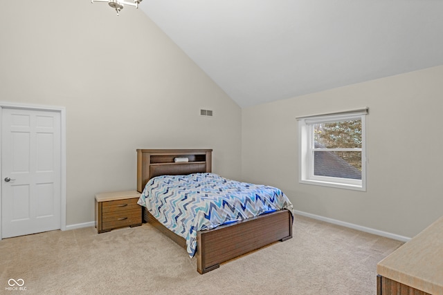 bedroom featuring light colored carpet and high vaulted ceiling