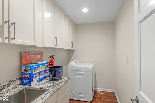 laundry area featuring cabinets, hardwood / wood-style floors, and washer / clothes dryer