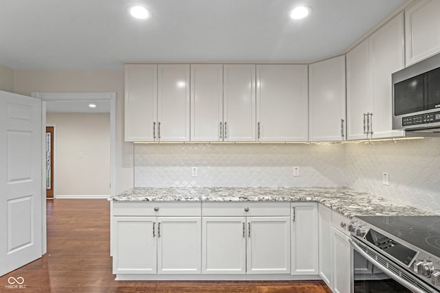 kitchen with white cabinets, backsplash, dark hardwood / wood-style flooring, and light stone counters