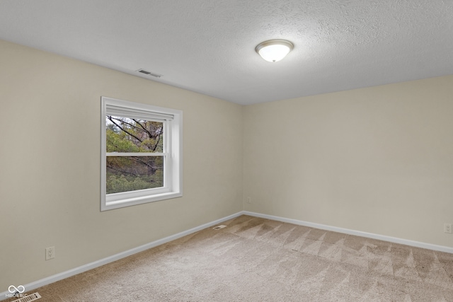 carpeted empty room featuring a textured ceiling