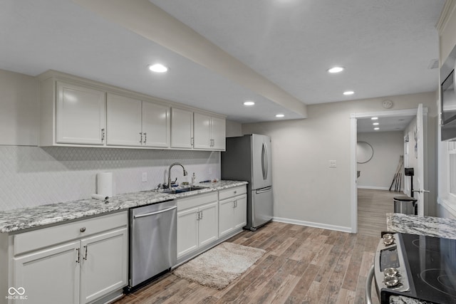 kitchen featuring sink, white cabinets, light hardwood / wood-style floors, and appliances with stainless steel finishes