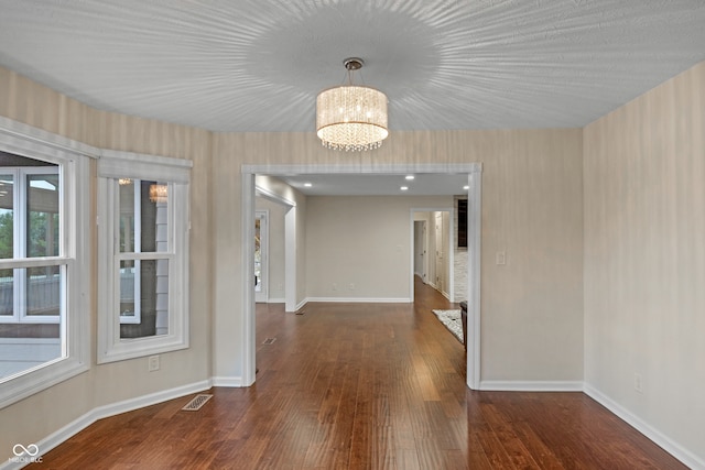 interior space featuring dark wood-type flooring and a chandelier