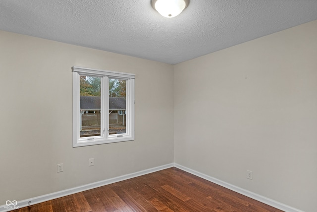 unfurnished room featuring a textured ceiling and dark hardwood / wood-style flooring