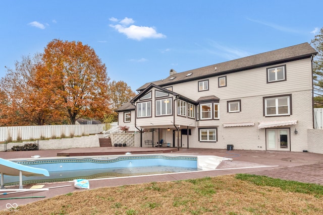 back of house with a fenced in pool and a patio