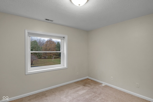 carpeted empty room with a textured ceiling