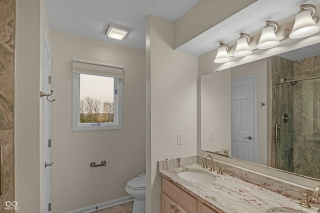 bathroom with toilet, vanity, a textured ceiling, and walk in shower