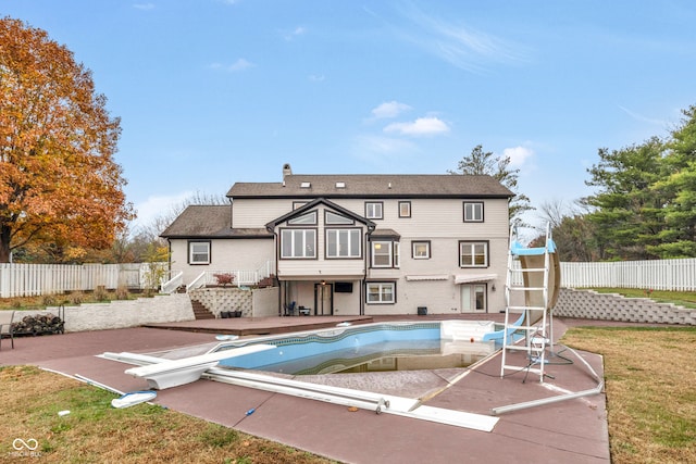 back of house with a fenced in pool and a patio area