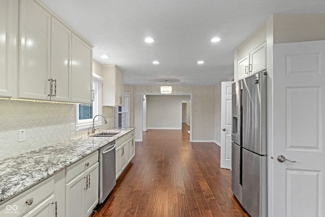 kitchen with white cabinets, dark hardwood / wood-style flooring, stainless steel appliances, and light stone counters