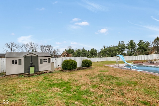 view of yard with a fenced in pool and a storage unit