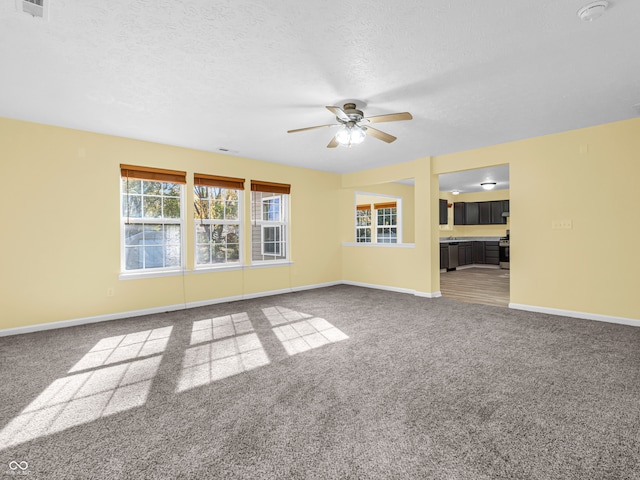 carpeted spare room with ceiling fan and a textured ceiling