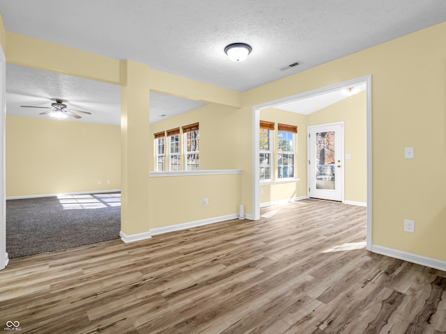 empty room with ceiling fan, light hardwood / wood-style floors, and a textured ceiling