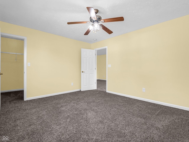 11411 Shady Hollow Ln, Indianapolis, IN 46229 - unfurnished bedroom featuring dark carpet, baseboards, a walk in closet, and ceiling fan