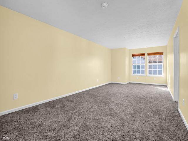 carpeted empty room featuring a textured ceiling