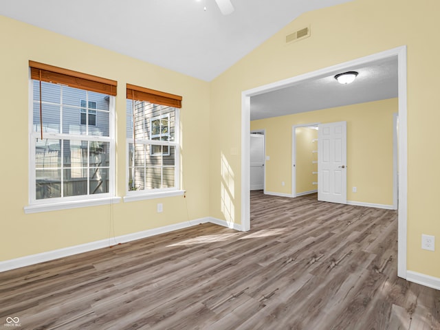 unfurnished room featuring hardwood / wood-style floors, ceiling fan, and vaulted ceiling