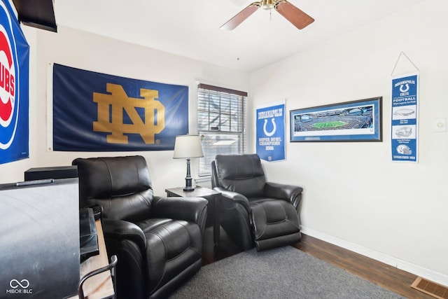 home theater room featuring dark wood-type flooring and ceiling fan