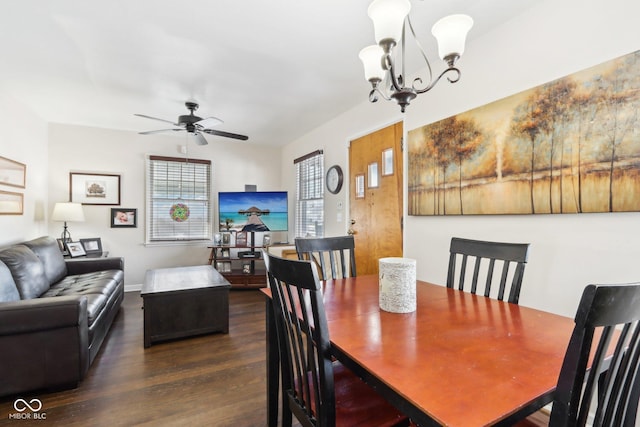 dining area featuring ceiling fan with notable chandelier and dark wood-type flooring