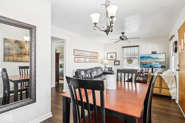 dining area with ceiling fan with notable chandelier and dark hardwood / wood-style flooring