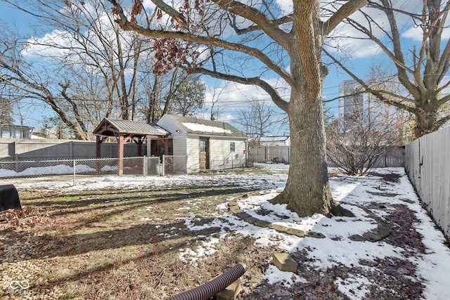 yard covered in snow with an outbuilding