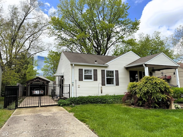 view of front of house with a gate, a detached carport, fence, concrete driveway, and a front lawn