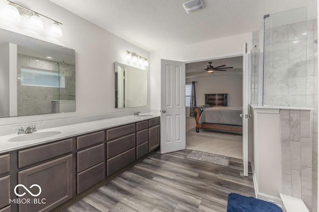 bathroom with a shower, a wealth of natural light, ceiling fan, and wood-type flooring