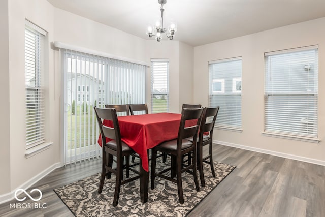 dining space with plenty of natural light, a chandelier, and dark hardwood / wood-style floors