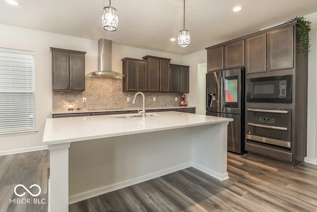 kitchen featuring dark wood-type flooring, sink, black appliances, and wall chimney range hood