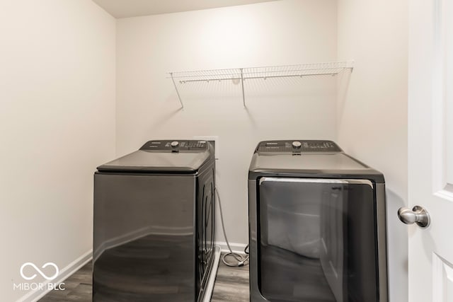 washroom with dark hardwood / wood-style floors and washer and clothes dryer